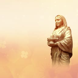 A golden-toned statue of Queen Ahilyabai Holkar holding a Shiva Linga against a soft, ethereal background.