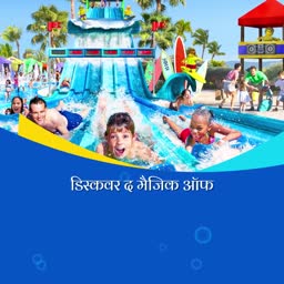 Children enjoying a water slide at an outdoor water park with bright blue water and sunny sky