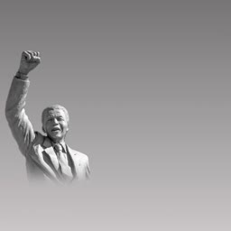 A monochrome statue of Nelson Mandela with his fist raised high in a sign of victory and protest
