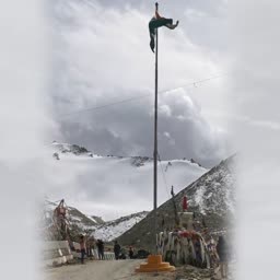 Indian tricolor flag flying high on a pole in the snowy Himalayan mountains