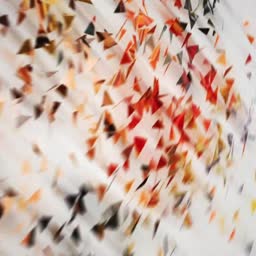A creative motion blur effect featuring scattered colorful geometric triangles on a white background