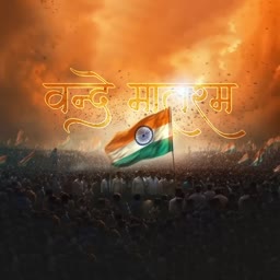 An Indian flag flying over a large crowd of people with the Hindi text Vande Mataram glowing in the sky at sunset.