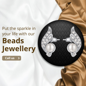 A pair of silver pearl and diamond wing-shaped earrings on a dark patterned circle with a silk fabric background