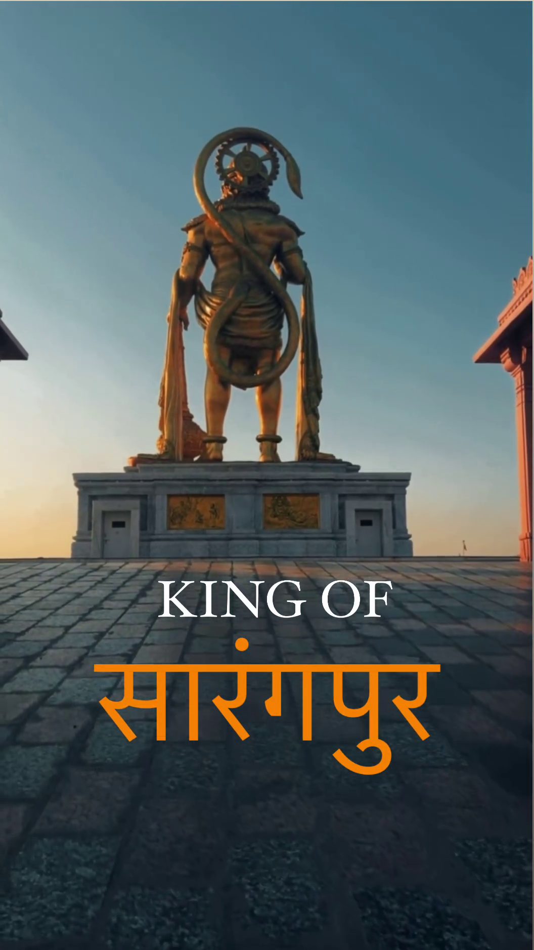 A golden statue of Lord Hanuman at Sarangpur temple against a sunset sky.