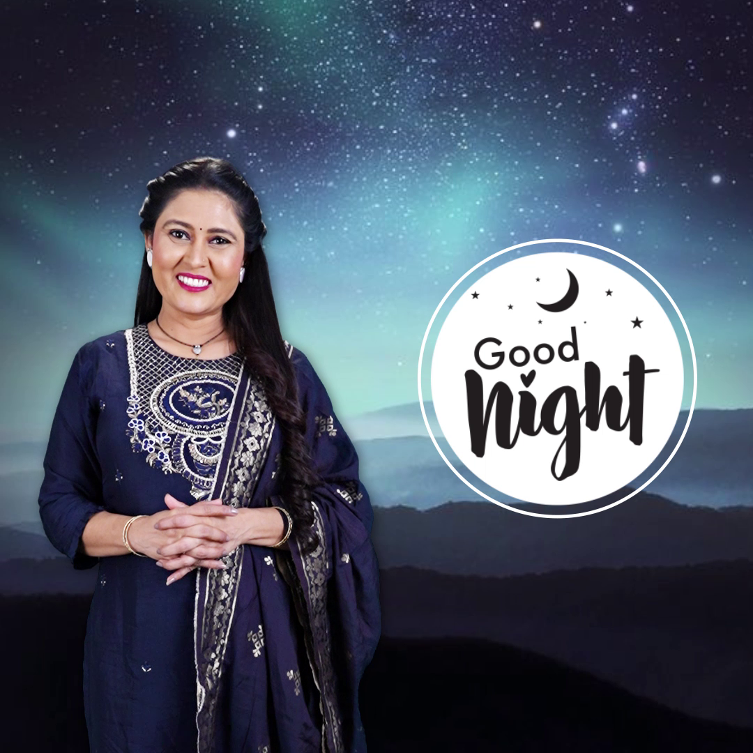 A smiling Indian woman in a traditional navy blue outfit, standing in front of a starry night sky background with a Good Night text overlay.