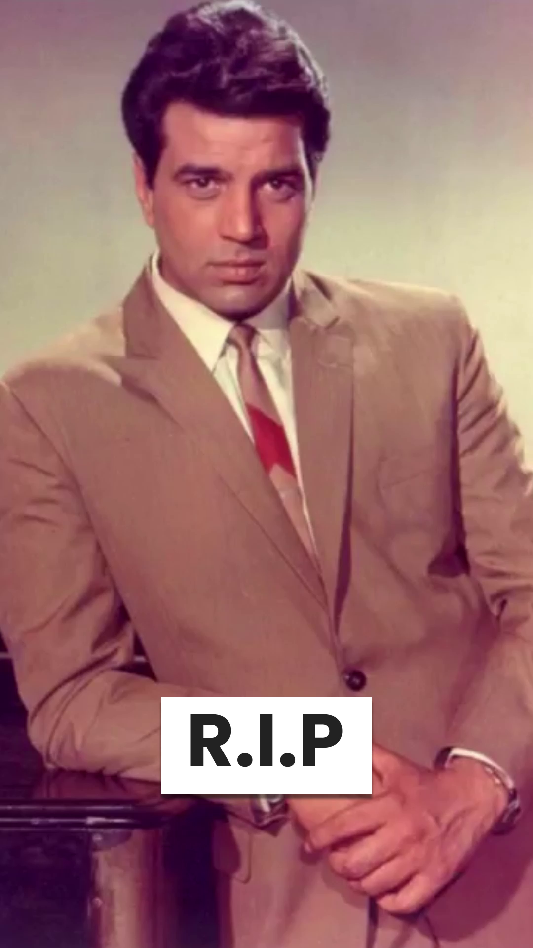 Portrait of young Indian actor Dharmendra wearing a formal suit with a R.I.P overlay