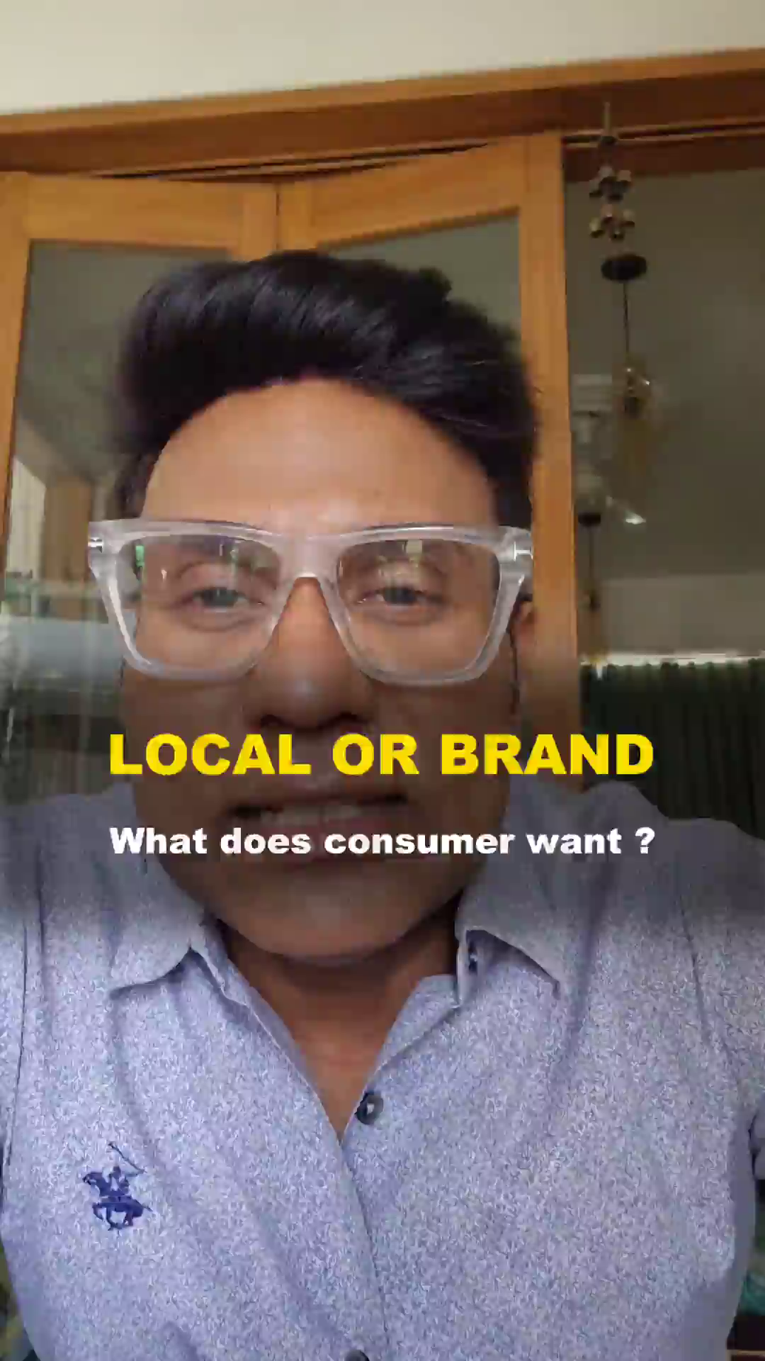 A man wearing glasses in front of a wooden background discussing local versus brand product preferences