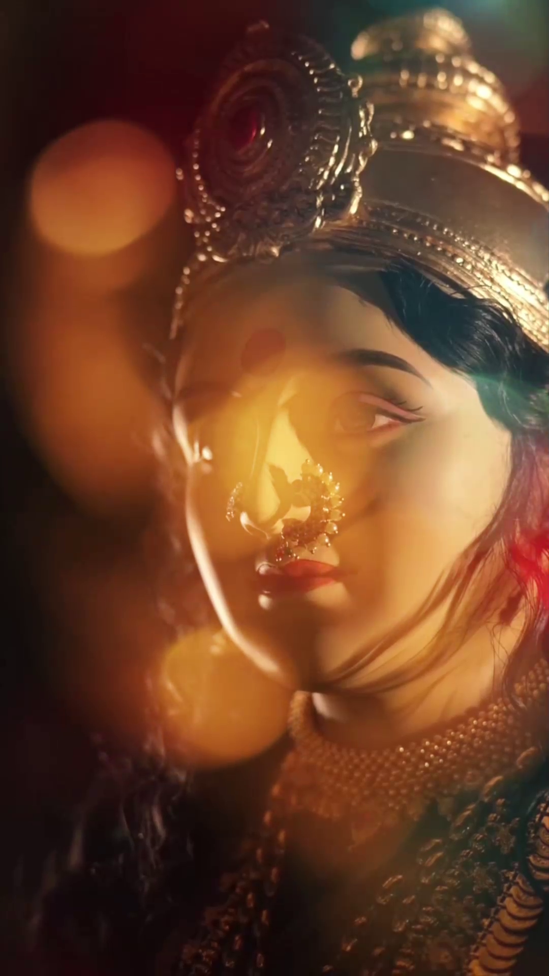 A beautifully illuminated portrait of the Goddess Durga idol featuring intricate jewelry and warm golden lighting.