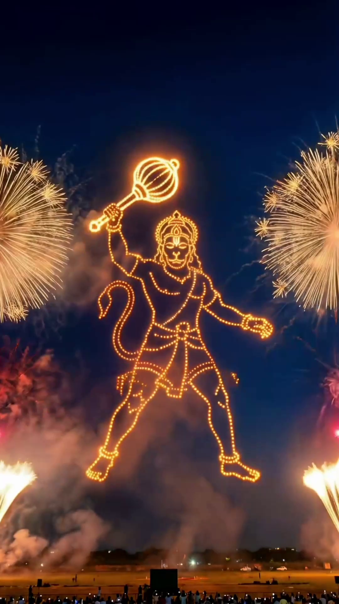 Spectacular drone light display of Lord Hanuman against a dark night sky with fireworks