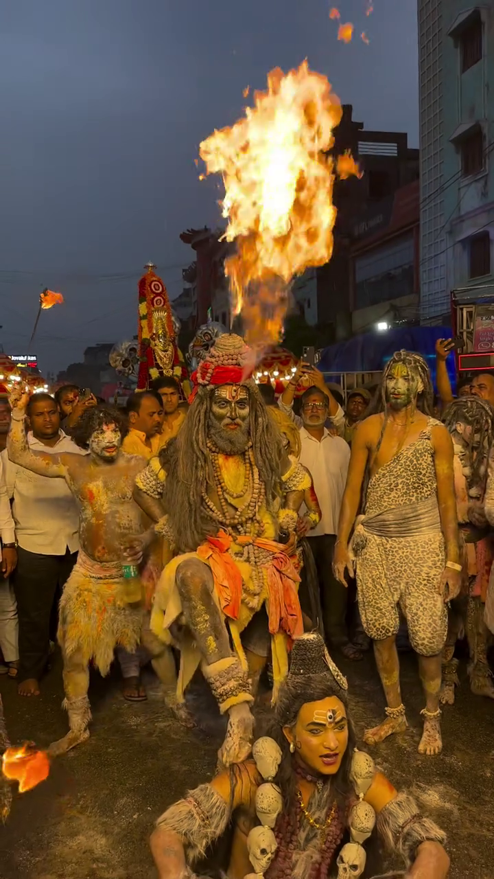 Performers dressed as Lord Shiva with fire breathing act at a street festival