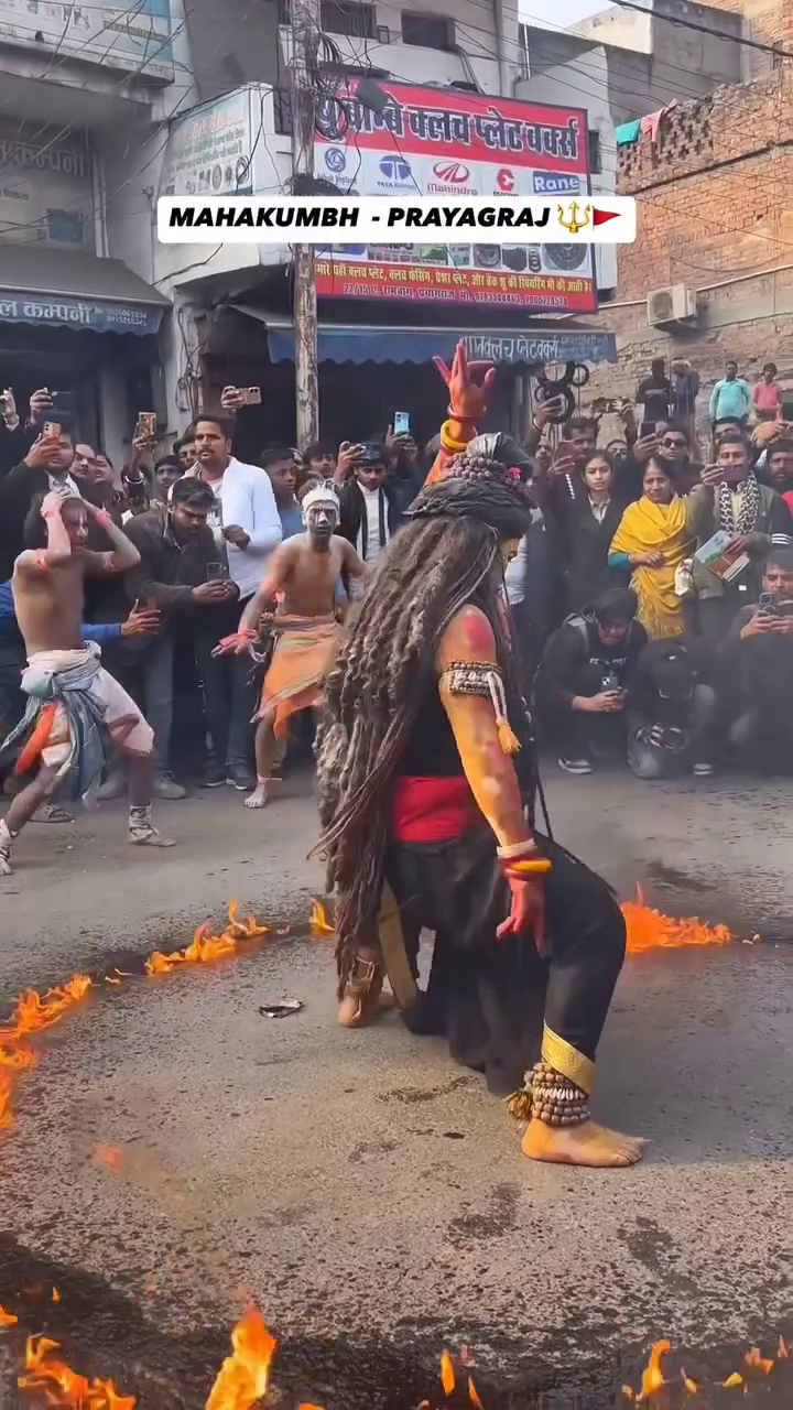 A performer dressed as Lord Shiva dancing within a ring of fire during the Mahakumbh in Prayagraj.