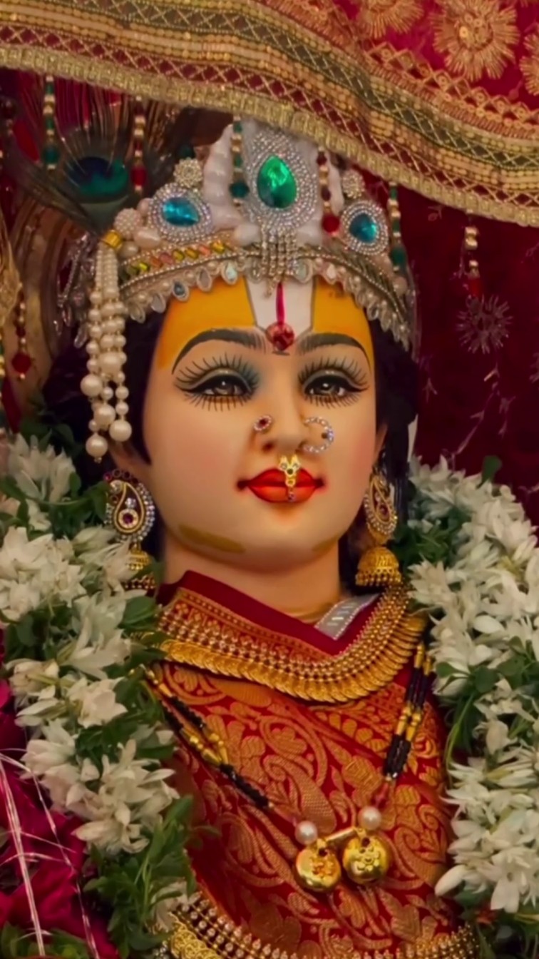 A beautifully decorated Hindu goddess idol adorned with traditional jewelry and white flower garlands.