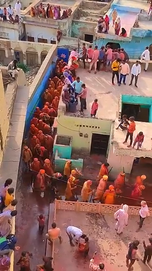 High-angle shot of people celebrating Holi with colorful powder in an Indian village street