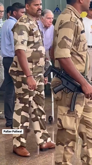 Ratan Tata walking with a walker accompanied by two armed CISF security personnel