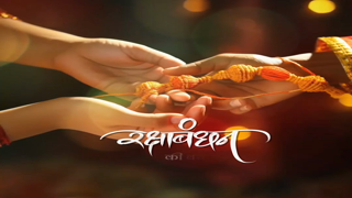 A close-up of hands tying a traditional Rakhi thread to celebrate the Indian festival of Raksha Bandhan.